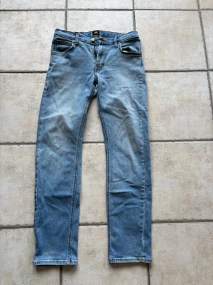 Ljusblå raka jeans från Lee - Snygga ljusblå jeans från Lee med klassisk femficksdesign och raka ben. Storleken är 30/32 och modellen heter daren zip fly, en liten defekt (se bild) skriv vid minsta fundering 💭➡️📩✅