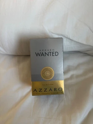 Azzaro Wanted Eau de Toilette 100ml - Azzaro Wanted Eau de Toilette i 100 ml flaska. Snygg förpackning i silver och guld med en unik design inspirerad av revolvertrumma. Doften är maskulin och modern, perfekt för dig som vill sticka ut. Kommer i originalkartong.