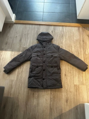 J Lindberg vinterjacka  - Säljer en mörkgrå supervarm vinterjacka från J Lindberg. Skicket är som nytt. Storlek M modellen är 180cm 80 kg