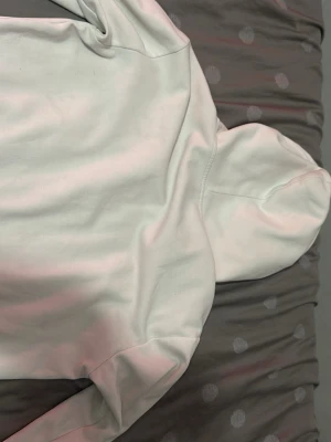 Vit zip hoodie från Polo Ralph Lauren - Vit hoodie med dragkedja från Polo Ralph Lauren. Klassisk design med huva, två fickor framtill och den ikoniska lilla loggan broderad på bröstet. Tillverkad i mjukt bomullsmaterial som är skönt att ha på sig. Perfekt för en avslappnad och stilren look.