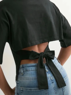 Tröja från Nelly med öppen rygg  - Svart tröja från Nelly med öppen rygg och band så man kan knyta där bak. Har klippt av lappen med skulle säga att det är storlek L men passar även mindre och större beroende på hur man vill att den ska sitta. Kan tyvärr inte skicka bild med hur den sitter på då den inte passar mig. Använd 1 gång.