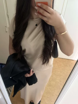 Beige satin set - Snygg beiget satin set, man får med både kjol och blusen. Bara använd 1 gång. Storlek 38 på båda delarna men passa även 36 och 40 skulle jag säga. Det är självklart nytvättat. Hör av er vid mer frågor eller bilder. Köpt från Cinco Ny pris : 1200 kr PRIS KAN DISKUTERAS