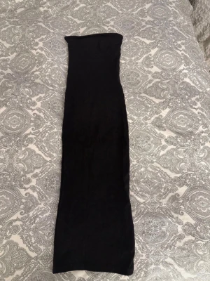 Svart tubklänning  - En enkel och stilren svart tubklänning i mjukt bomullsmaterial. Klänningen är ärmlös och har en tight passform som framhäver figuren. Perfekt för dig som gillar minimalistisk stil och vill ha en klassisk bas i garderoben. Storlek xs men passar även S då den är så stretchig.