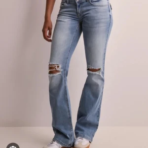 Nelly Ljusblå bootcut jeans med slitningar - Säljer mina Nelly jeans pga att de är för stora. Jeansen är i gott skick, men ser lite dåliga ut på bilden pga att de legat ihopvikta i en låda i flera månader. Ser bra ut på! 💞 