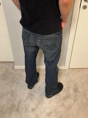 Levis 506 Standard - Levis 506 standard. Bra skick. Defekt: Sliten gren [se bild 3]. Mått Midja 43.5cm Lår: 32cm Benslut: 22cm Ytterben: 102cm. Modellen på bilderna är 183cm och väger 67kg. Skriv vid funderingar!