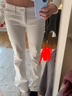 Vita  jeans med låg midja - Säljer ett par vita bootcut jeans med låg midja och klassiska fem fickor. Jeansen har en snygg passform och stängs med knapp och dragkedja. Perfekta för dig som vill ha en clean och fräsch look till vardags. Har sytt om dem Lågmidjade så finns ett stygn mellan benen men inget man märker.  