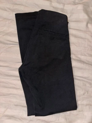 Svarta chinos från Peak Performance - Snygga svarta chinos från Peak Performance i storlek XS. Klassisk rak passform med diskreta bakfickor och mjukt, bekvämt tyg. Taight modell. (Knappen är borta, men inget som stör funktionen) Super fina på 🌸