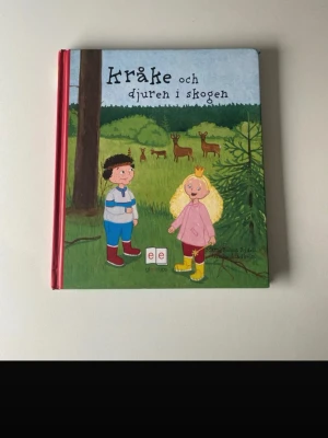 Kråke och djuren i skogen - En färgglad bilderbok med hårda pärmar som handlar om Kråke och hans äventyr bland djuren i skogen. Boken har illustrationer på framsidan med barn och djur i en grön skogsmiljö. Perfekt för dig som gillar natur och spännande berättelser.