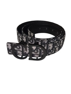 D.i.O.R Bälte - D.i.O.R C.D Bälte  Exklusivt bälte med modern och stilren design 💎 Mönstrat band i klassisk D.i.O.R-stil som ger en lyxig och trendig look ✨ Mattsvart CD-spänne som ger en clean och premium känsla 🖤 Perfekt för att lyfta både vardags- och festoutfits 👌  🔹 Märke: D.i.O.R 🔹 Färg: Svart / Grå med svart spänne 🔹 Skick: Mycket fint 🔹 Material: Canvas / Läder  📦 Snabb leverans 💎✨