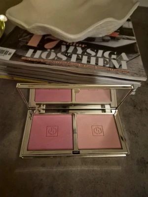 Rosa och nuderosa rougepalett - Snygg rougepalett från Jouer med två nyanser: en kall rosa och en varm persikoton. Paletten har en spegel och ett stilrent guldigt fodral med blommönster. Perfekt för att skapa fräsch lyster och färg på kinderna.använd några gånger. Fina färger. Färger seduce me oxh tease me. Fin palett av äldre modell!!!