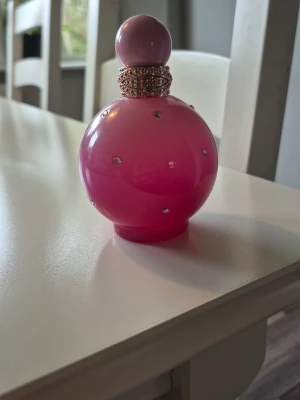 Britney Spears Candied Fantasy  - Säljer en ikonisk Fantasy parfym från Britney Spears. 100ml från början men jag har knappt använt den. Den har förvarats svalt & mörkt. Beskrivs som följande: Öppningsnoter av Bubblegum Delight, saftig jordgubbe och sprudlande apelsin ger ett ljuvligt dekadent första intryck. Rosa hibiskus, jasmin sambac absolute och liljekonvalj framhäver dess blommiga hjärta och omger dig med en lycksalig omfamning. Mysk, sandelträ och Pink Velvet Cupcake Accord ger kvarvarande inslag av sötma.