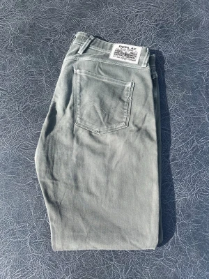 Gröna Replay jeans  - Snygga gröna jeans från Replay med klassisk femficksdesign och rak passform. Jeansen har en diskret logga på bakfickan och är tillverkade i mjukt denimtyg med stretch för extra komfort. Perfekta för en avslappnad och trendig look. Modell anbass storlek W34 L32
