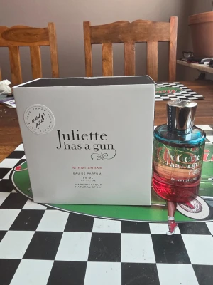 Juliette Has a Gun Miami Shake parfym - Parfymen Miami Shake från Juliette Has a Gun kommer i en snygg glasflaska med färgskiftning från blått till rött och har ett silvrigt lock. Flaskan rymmer 50 ml Eau de Parfum och levereras i en stilren vit kartong.