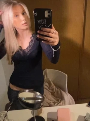 Intimissmi tröja  - Snygg mörblå intimissmi tröja med v-ringning och spetsdetaljer längs halsringningen. Figurnära passform som framhäver siluetten. Perfekt att styla med jeans eller kjol för en trendig look