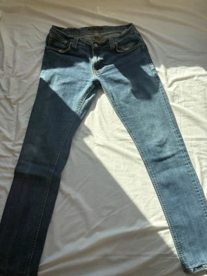 jeans från Nudie (pris kan diskuteras) - Säljer ett par klassiska blå skinny jeans från Nudie Jeans . De är storlek 32 men tvättade så rekomenderar för storlek 31. Jeansen har fem fickor, dragkedjegylf och är tillverkade i mjuk denim med stretch. Perfekta för dig som gillar en smal passform och tidlös stil.
