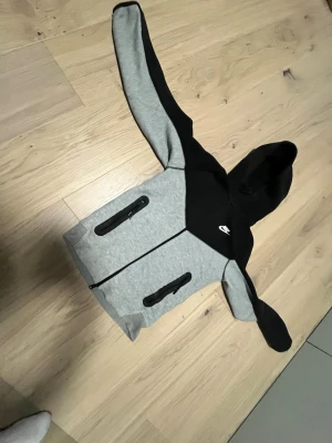 grå svart nike tech - Grå svart Nike tech, inte jätte använda och inga större problem mer en att dragkedjan kan vara lite trög ibland