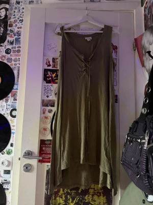 Olivgrön klänning🫒 - Olivgrön klänning🫒med v-ringad krage och snörig framtill. Den är ärmlös och gjort på stretchigt och luftigt material. Perfekt på sommarennnn!                      ‼️fråga efter mått/se hur den ser ut på‼️.                   Den är S fast passar storlekar upp till XL!!