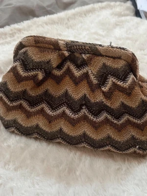 Trendig clutch!  - Märket är Beck Söndergaard, men köpt på Vinted! Använd en gång men den jag köpte den är bilderna från🪭 brun/grön/vit färgad!