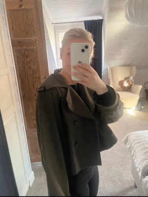 mörkgrön trenchcoat - Jättefin mörkgrön trench coat ifrån hm. skicket är mycket bra o passar bra på mig som är 166.