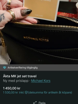 Svart Michael Kors Jet Set handväska - Snygg svart Jet Set Travel handväska från Michael Kors i slätt läder med guldfärgade detaljer och dragkedja. Väskan har ett stilrent och klassiskt utseende med logotyp framtill och flera fack inuti för smart förvaring. Perfekt accessoar för dig som gillar lyxig och tidlös design.