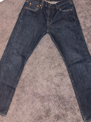 Mörkblå Levi's Premium jeans - Snygga mörkblå jeans från Levi's Premium med klassisk femficksmodell och kontrastsömmar. Jeansen har normal passform och är tillverkade i bomull för en skön känsla. Perfekta till alla tillfällen där du vill ha en clean och tidlös look.