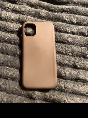 Två stilrena mobilskal i silikon iphone 11 - Säljer två mobilskal i mjukt silikonmaterial, ett i beige och ett i svart. Båda har en enkel och clean design med rundade hörn och öppning för kamera. Perfekt för dig som vill ha ett minimalistiskt skydd till din mobil.