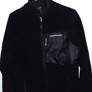 Svart HELT NY  Peak Performance hoddie  - Svart hoddiefflecce/sommar kvällar typ.  från Peak Performance med dragkedja framtill och en snygg  och lång ärm, perfekt för dig som gillar stilren och sportig look. Helt ny finns bilder fler bättre vid intresse  pris t passar s  oxå  säljes billigt då jag behöver  pengar tyvärr till annat ..endast testas bara hemma