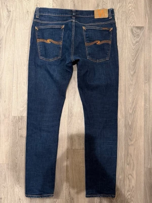 Nudie Jeans Mörkblå W34/L32 - Slim/Skinny Fit - Mycket fint skick. Storlek W34/L32. Mått - Midja: 42,5cm, Ytterbenslängd: 100cm, Benöppning: 15cm. Modellen är 185cm & 65kg. Hör av dig vid funderingar!🤝