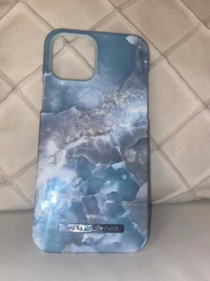 Blått marmormönstrat mobilskal - Oanvänt mobilskal från Ideal of Sweden som passar iPhone 12 Pro Max. Färgen/designen heter Azura Marble med snyggt marmormönster i blå nyanser. Det ser stilrent och modernt ut💙✨  Skalet är helt nytt och ligger kvar i originalförpackningen📦 (dock trasigt)  Säljes åt annan person, därför har det inte kommit till användning.
