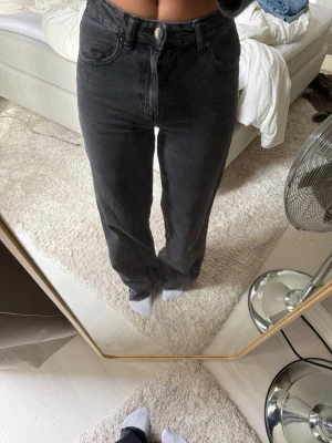 Svarta raka jeans med hög midja - Säljer ett par svarta raka jeans Jeansen har en knappgylf och är tillverkade i ett kraftigt denimtyg. Storlek 32 men sitter som en 34, jag är ca 170cm