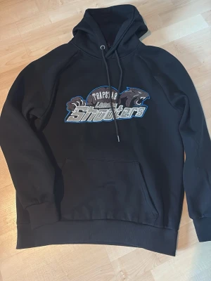 Svart Trapstar hoodie med tryck - Hoodie från trapstar, säljer pga att den är för stor för mig, det står strl S men sitter som M, hör av er vid mer frågor🌟