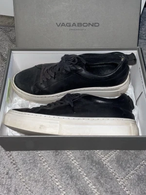 Svarta Vagabond sneakers i läder - Stilrena svarta sneakers från Vagabond med ovandel i läder och tjock vit sula. Klassisk låg modell med svarta skosnören och diskret design som passar till det mesta. Perfekta för dig som gillar minimalistisk och tidlös stil.