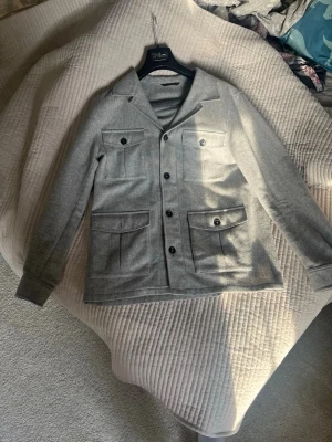 Grå overshirt från Oscar Jacobson - Stilren grå overshirt från Oscar Jacobson! Grymt skick och snygg, kan tänka mig gå ner i pris vid snabb affär!🤝