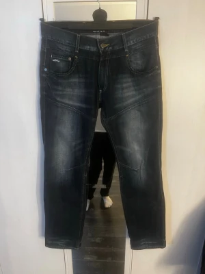 Mörkblå jeans från Grant - Säljer ett par mörkblå jeans från Grant, modell 989. Jeansen har snygga slitningar och kontrastsömmar, klassisk femficksdesign och raka ben. Perfekta för dig som gillar en avslappnad men ändå stilren look. Hör av er vid frågor! W33 L32