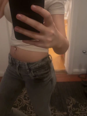 Gråa slim fit jeans med slitningar - Säljer ett par gråa slim fit jeans med lätt slitna detaljer och klassisk femficksdesign. Jeansen har en låg midja och raka ben, perfekt för en avslappnad och trendig look. Materialet är denim och de är riktigt bekväma att bära. Strlek 158