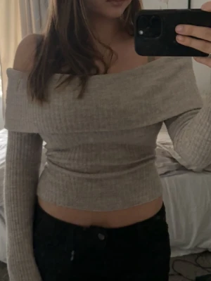 Off shoulder-topp - Ribbstickad off-shoulder topp i beige/grå från H&M. Mjuk och strechig med snygg passform. Passar perfekt till byxor eller kjol 🌸 Knappst använd så inga fel på den 😊