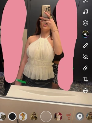 Vit omlott halterneck topp - Säljer en snygg vit halterneck topp med omlott-effekt och volang nedtill. Toppen är ärmlös och har en luftig, flowy passform som ger en chic look. Perfekt att styla med kjol eller jeans för en trendig outfit.