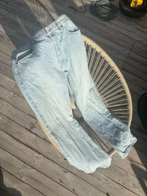 Ljusblå raka jeans Just Junkies - Säljer ett par ljusblå jeans från Just Junkies med rak passform och klassisk femficksdesign. Jeansen har hög midja och är tillverkade i denim med en snygg tvättad look. Perfekta för en avslappnad och trendig stil.