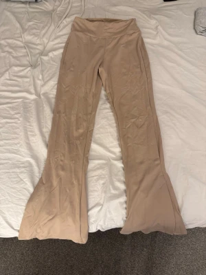 Beige utsvängda leggings - Säljer ett par beige leggings med utsvängda ben och hög midja. De är stretchiga och mjuka. Köpta från SHEIN i storleken Petite XS för något år sedan men har bara använt dem ett fåtal gånger.