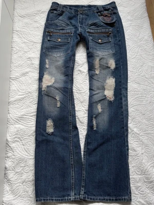 vintage ripped bootcut jeans  - midja: 77cm, innerben: 81cm, ytterben: 107cm, benöppning platt: 23cm. Köpta i Japan, se tag  