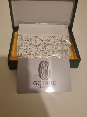 Vit kortfodral från G4yard - Snyggt vitt kortfodral från G4yard med det klassiska mönstret och logotypen tryckt på framsidan. Tillverkad i canvas och läder, med flera fack för kort. Kommer i originalask med tillhörande tygpåse och certifikat.