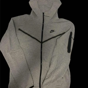 Grå hoodie från Nike - Säljer en grå hoodie från Nike med dragkedja och huva för 350kr