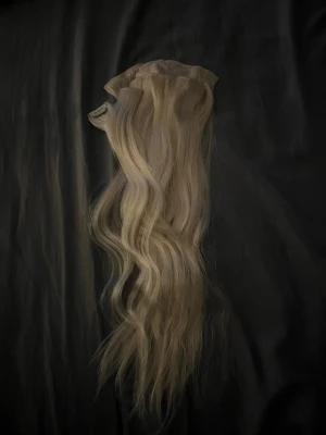 Blonda clip-on löshår - Säljer ett set med blonda clip-on löshår. Perfekt för dig som vill ha längre och fylligare hår på nolltid. Löshåret har en naturlig blond ton som smälter in snyggt med ditt eget hår. Clipsen gör det enkelt att sätta i och ta ur. Det är naturligt hår från delightfulhair i färgen extra ljusblond #6001. De är 50 cm 110g.