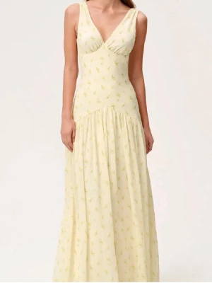 Jättesöt Adoore klänning💕 Endast använd en gång  -  långklänning i ljusgul ton med små blommiga detaljer. Klänningen har v-ringad hals, breda axelband och en mjukt utsvängd kjol. Perfekt för sommarens alla tillfällen.