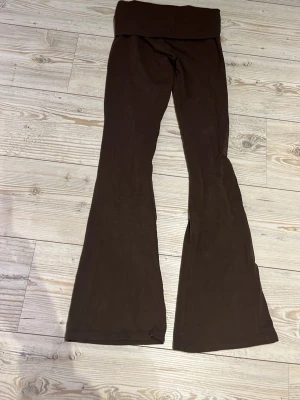 Bruna utsvängda leggings - Säljer ett par bruna byxor med utsvängda ben och som man viker vid midjan. De är mjuka och stretchiga, perfekta för en avslappnad och trendig look. Passar dig som gillar bekväma men ändå snygga byxor.