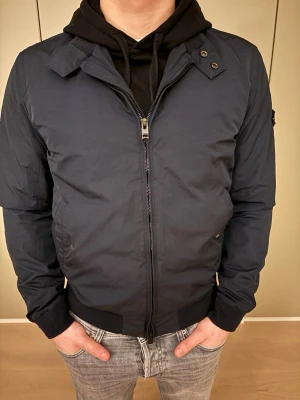 J.Linderberg jacka - Säljer denna sjukt snygga J.Linderberg jackan i ganska mörk mörkblå, str M men hade passat S, en knapp är borta på fickan men ingen alls man tänker på, kom dm för bilder och frågor.