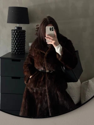 Mörkbrun äkta minkpälsjacka lång  - Äkta minkpäls lång kappa. En fantastisk handgjord vintage minkpäls i toppkvalitet med vacker brodering på insidan, fickor och 3 knäpp på framsidan . Pälsen är otroligt mjuk, tät och välbevarad med fin tyngd och klassisk passform. Ett exklusivt plagg som inte tillverkas på samma sätt idag och passar dig som uppskattar äkta hantverk och tidlös vintage. Storlek uppskattas M–L beroende på hur du vill att den ska sitta. Saknar märkning, handgjord/ateljésydd. 