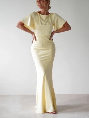 Ljusgul långklänning med vida ärmar, balklänning - Elegant ljusgul långklänning med vida, korta ärmar och figurnära passform. Klänningen har en mjuk, svepande siluett och rund halsringning. Perfekt för dig som vill sticka ut med en stilren och modern look. Helt ny, aldrig använd. Fel storlek och kunde ej lämna tillbaka. Kan fraktas