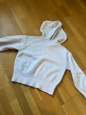 Ljusrosa cropped hoodie - Mysig ljusrosa hoodie i croppad modell med bred ribbad mudd nedtill och vid ärmsluten. Andvänd fåtal gånger