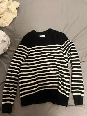 Svartvit randig stickad tröja från pier one  - Säljer en svart stickad tröja från Acne Studios med vita horisontella ränder. Tröjan har rund halsringning, långa ärmar och ribbade muddar vid ärmslut och nederkant. Perfekt för dig som gillar klassisk men trendig stil. inge defekter säljer för jag inte använder mer